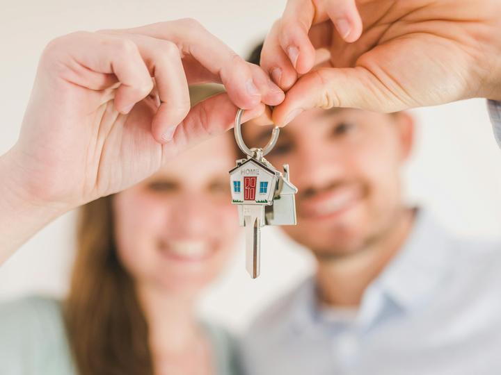 two people holding house keys