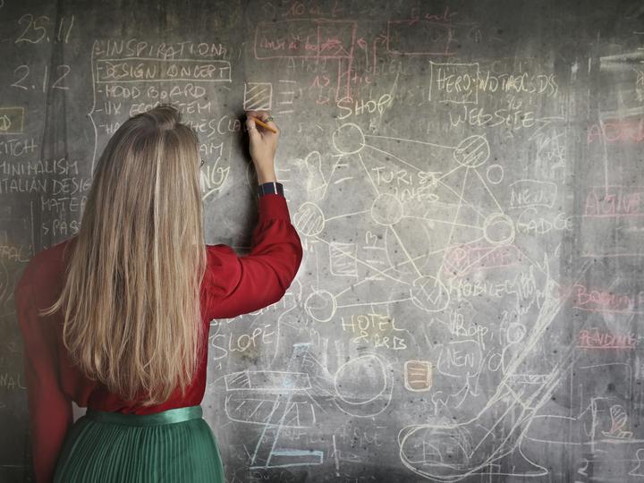 woman writing on chalkboard