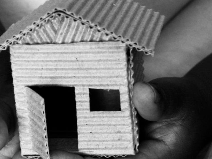 cardboard house being held by hands