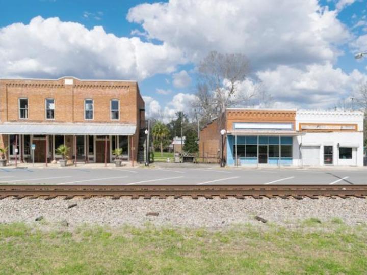 two old buildings across a railroad track