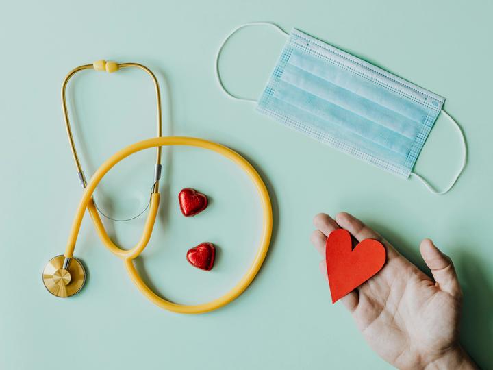 a paper heart, a doctor's mask, and a stethoscope laying flat