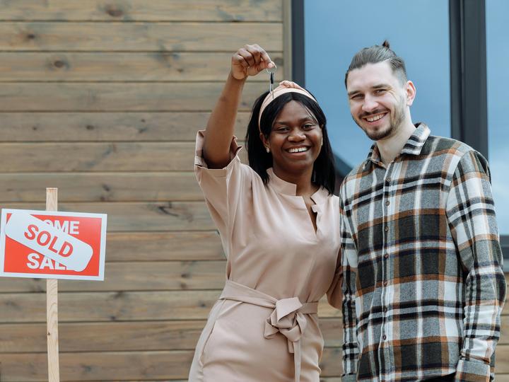 couple holding a key to a new home