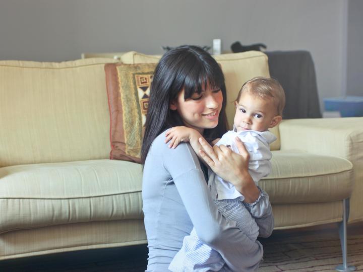 woman holding a baby in a living room