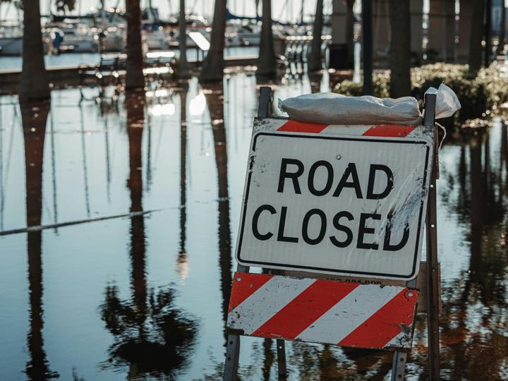 a road closed sign with water around it