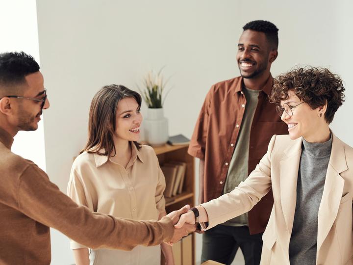 a small group and 2 people shaking hands