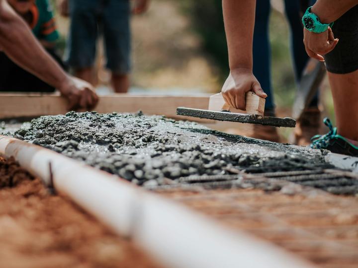 people laying concrete and building