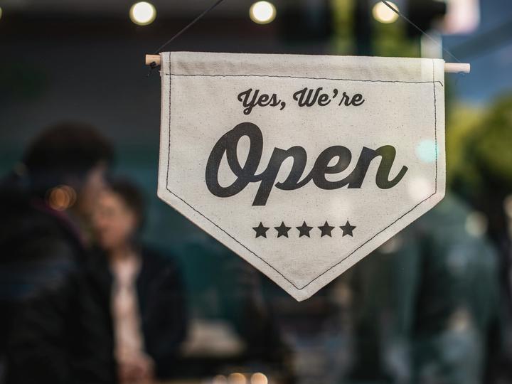 small flag that says "yes, we're open"