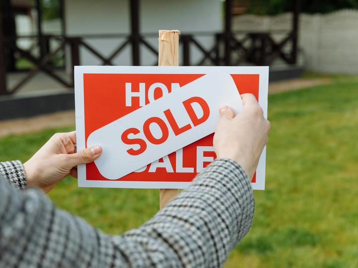 a for sale sign with a sold sign on top