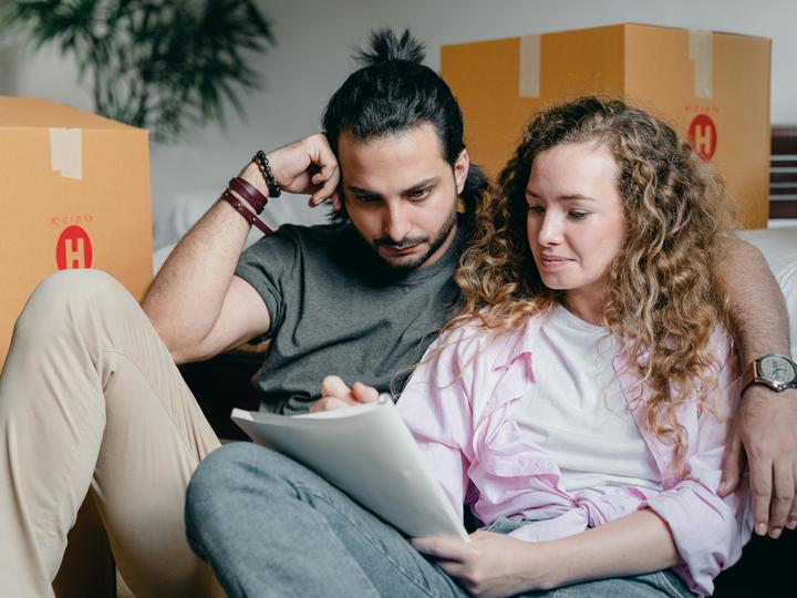 man and woman with boxes around them looking at a list