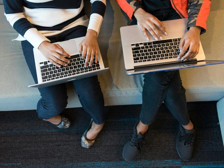 two people working on laptops