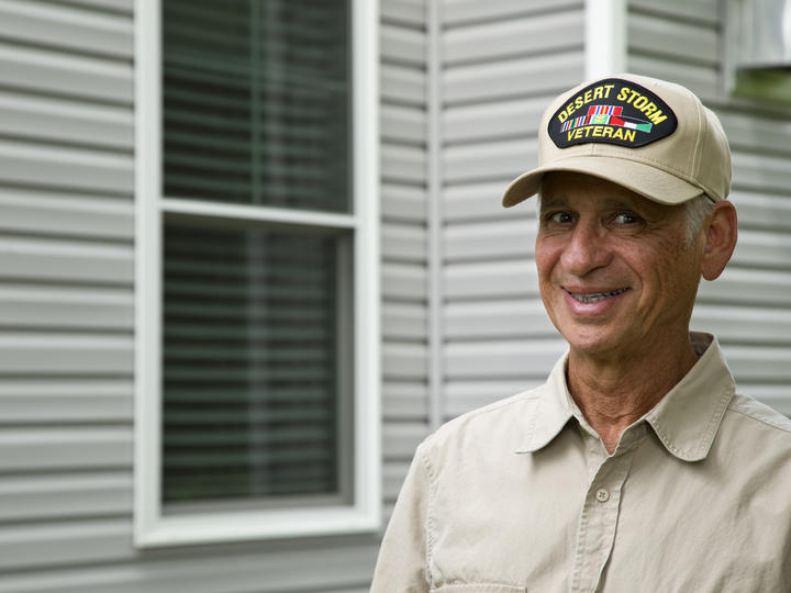 veteran standing in front of house