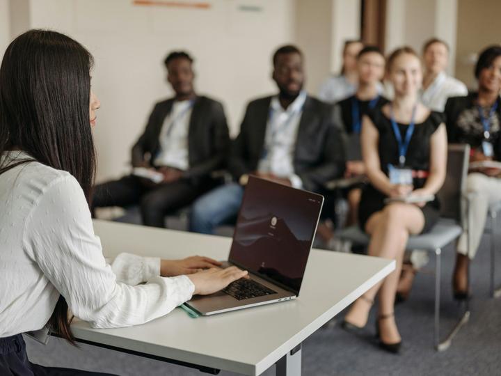 Women using laptop at board meeting.