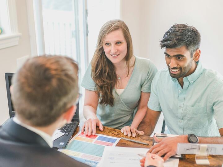 A Smiling Couple Talking to the Agent