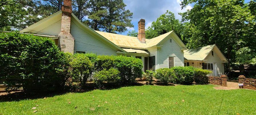 White one-story house with yellow roof and front lawn