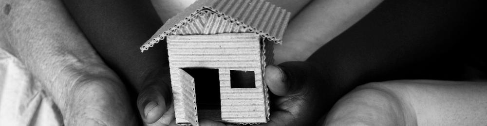 cardboard house being held by hands