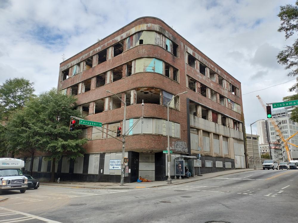 Photo of an art deco corner office building in disrepair